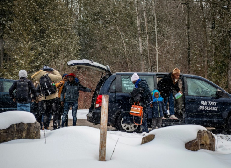 Migrants grab a taxi from a bus station in Plattsburg in New York State to the Roxham Road border crossing into Canada