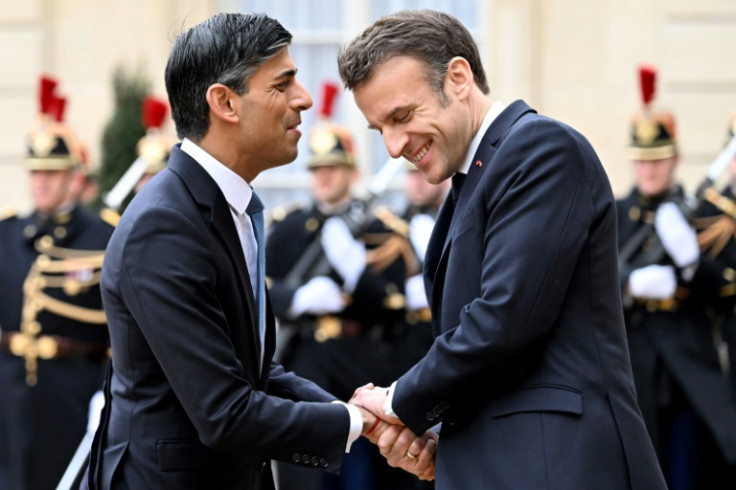 France's President Emmanuel Macron shakes hands with Britain's Prime Minister Rishi Sunak as he arrives at the Elysee Palace