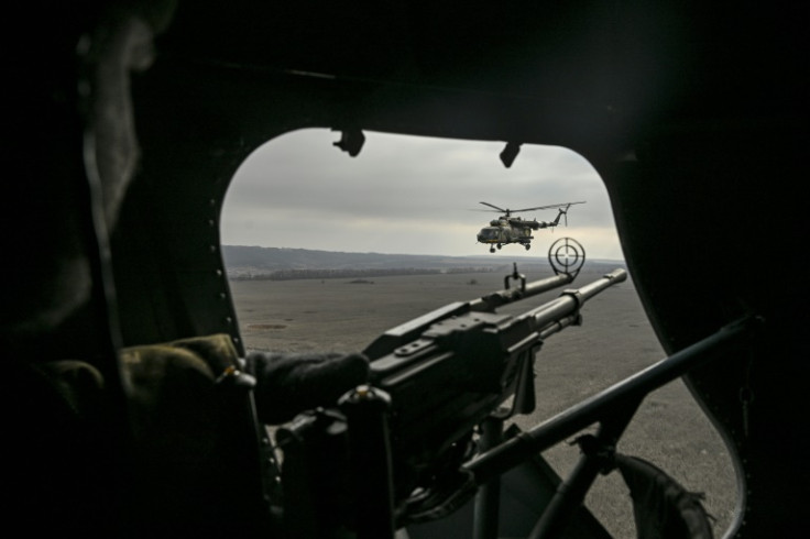 A Ukrainian door gunner watches a second Mi-8 helicopter over eastern Ukraine