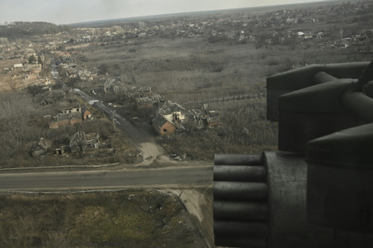 A Ukrainian Mi-8 helicopter flies over a destroyed village in eastern Ukraine