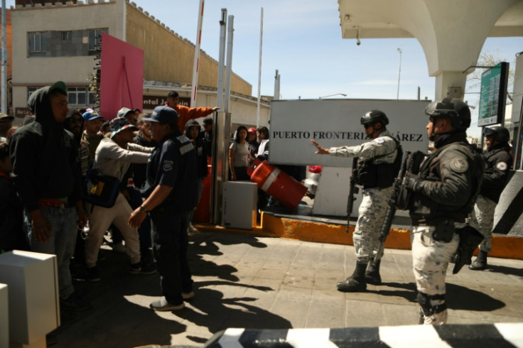 US border guards move to close the bridge as hundreds of people attempt to cross
