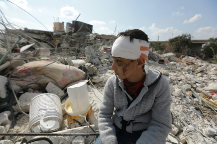 A Syrian boy sits amid the rubble of his family home in Jindayris, in the rebel-held part of Syria's Aleppo