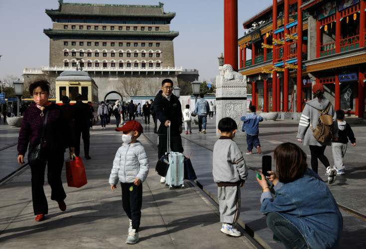 People walk at a tourism site in Qianmen street, in Beijing,