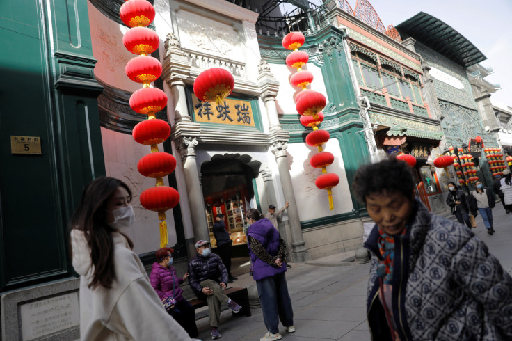 People walk past shops near the tourism site of Qianmen Street, in Beijing