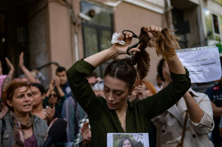 An Iranian living in Turkey, Nasibe Samsaei, cuts her ponytail off outside the Iranian consulate in Istanbul in protest at her country's strict dress code for women