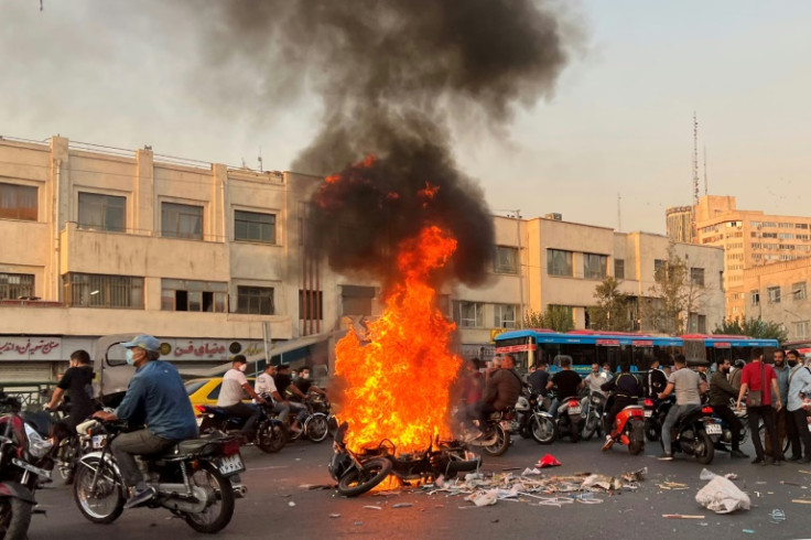 Protesters set a motorbike on fire at a demonstration in Tehran on October 8