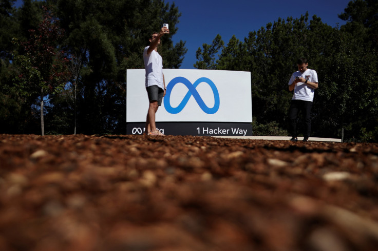 A man takes a selfie in front of a sign of Meta, the new name for the company formerly known as Facebook, at its headquarters in Menlo Park