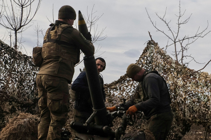Anggota layanan Ukraina memuat peluru ke mortir sebelum menembak ke arah pasukan Rusia di luar kota garis depan Bakhmut