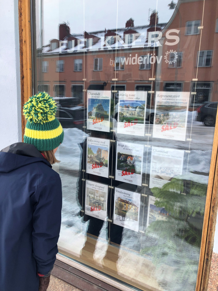 Person looks at real estate advertisements on a display window in Stockholm