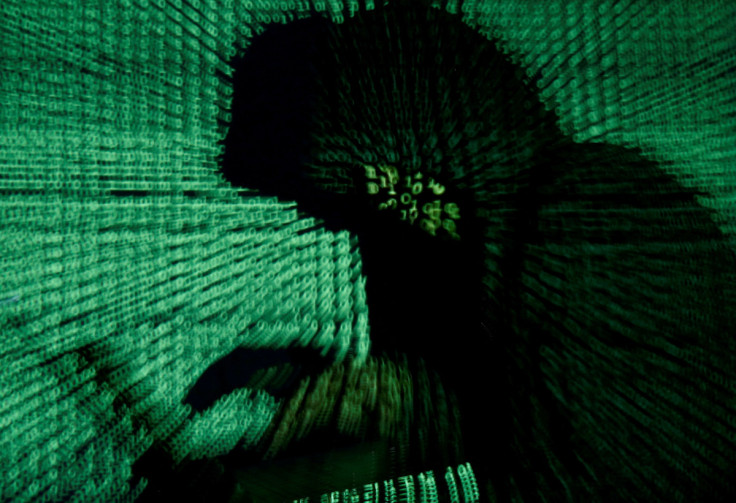 Man holds laptop computer as cyber code is projected on him in this illustration picture