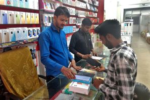 Customer checks a Samsung mobile phone before purchasing it, in a mobile store in Lucknow
