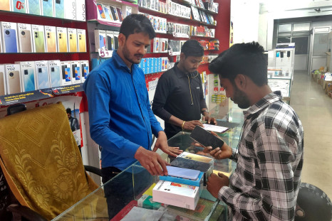 Customer checks a Samsung mobile phone before purchasing it, in a mobile store in Lucknow