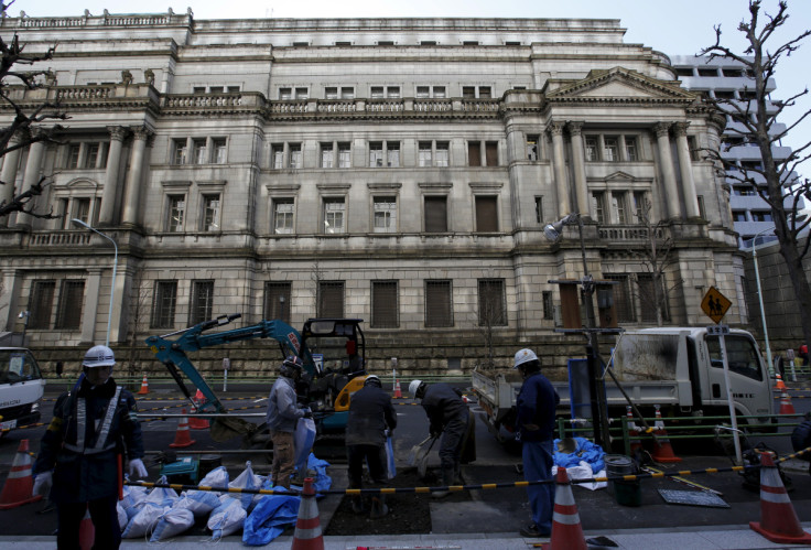 Labourers work in front of the Bank of Japan (BOJ) building in Tokyo