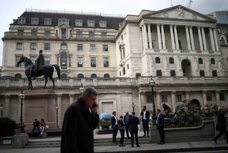 People stand outside the Bank of England in the City of London financial in London