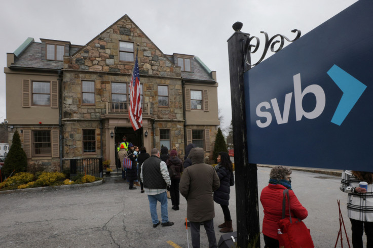 Customers wait in line outside a branch of Silicon Valley Bank in Wellesley