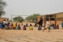 A teacher and her pupils play in a yard at a school near a site for displaced people on the outskirts of Ouallam, Niger in October 2022