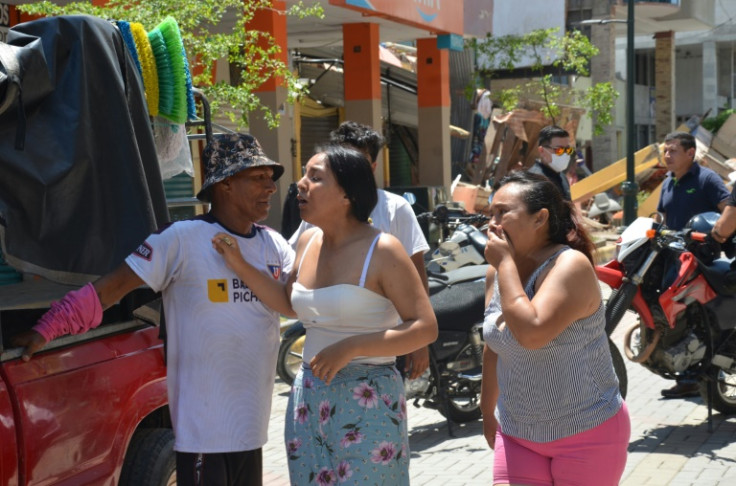 Residents cry after an earthquake destroyed buildings in the city of Machala, Ecuador on March 18, 2023