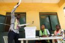An electoral official holds up a ballot paper during the vote counting process after the gubernatorial election at a polling unit, in Lagos