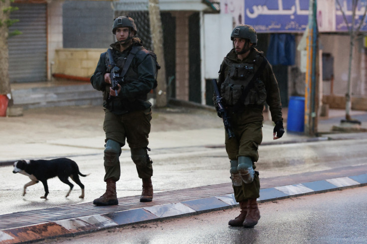 Israeli troops stand guard at the scene of a shooting, in Huwara
