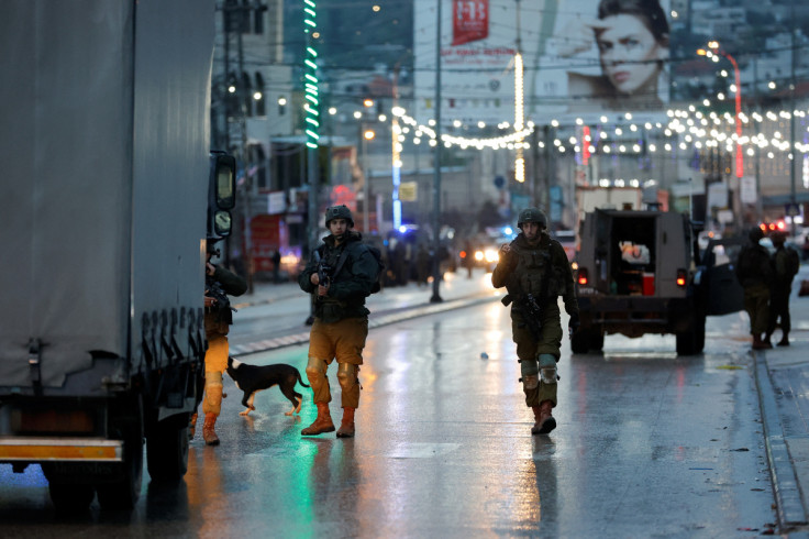 Israeli troops stand guard at a shooting scene in Huwara