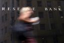 An office worker walks past the Reserve Bank of Australia (RBA) building in central Sydney, Australia