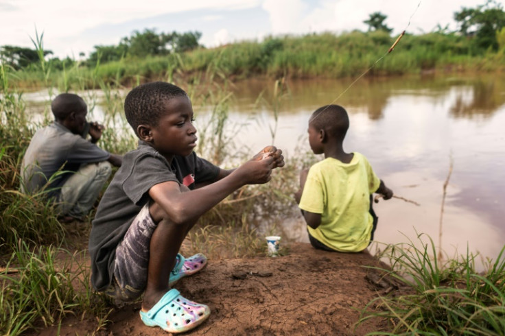 Boys fish in a Malawi river in February 2023 in an area highly affected by a cholera outbreak due to scarce access to clean drinking water
