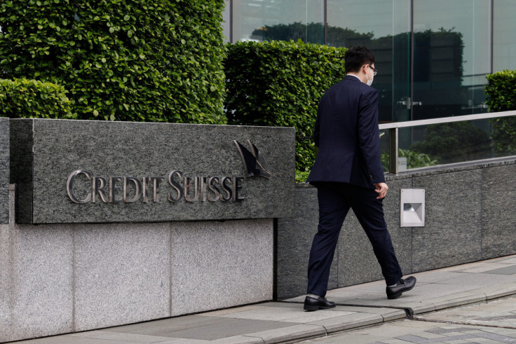 A person walks past the logo of Credit Suisse outside its office building in Hong Kong