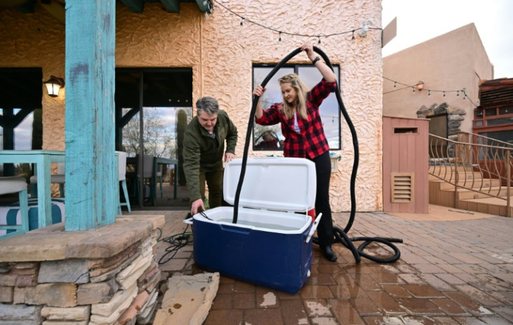 Wendy and Vance Walker use water coolers to collect rainwater from their rooftop to flush their toilets