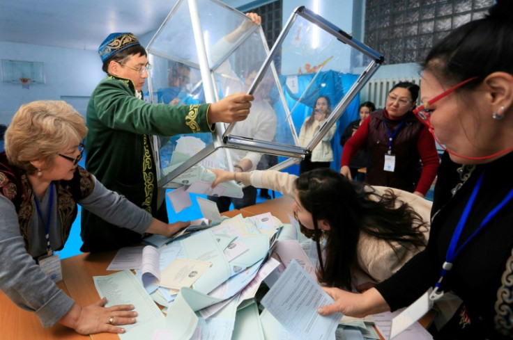 Members of a local electoral commission empty a ballot box at a polling station after parliamentary elections in Almaty