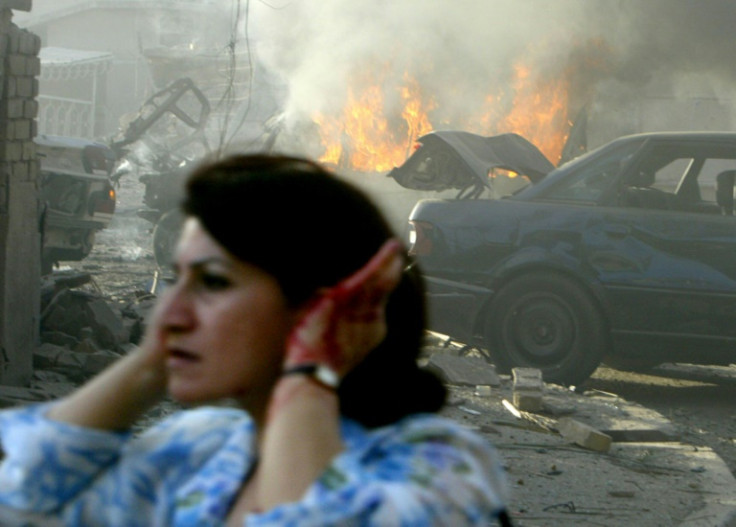 A wounded Iraqi woman flees the site of two car bombs that exploded in quick succession near two Baghdad churches, in this file photo from August 1, 2004