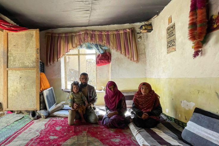 The family of Khair Mohammad, who has lost his legs due to mine explosion, poses for a photograph in their house in Kabul