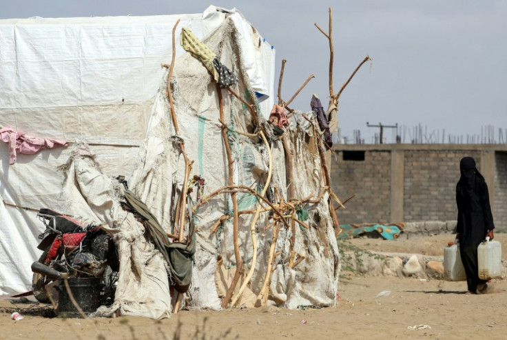 A woman carries water at a camp in the western province of Hodeida for Yemenis who fled the fighting