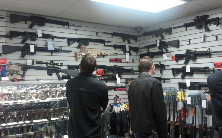 Customers view semi automatic guns on display at a gun shop in Los Angeles California