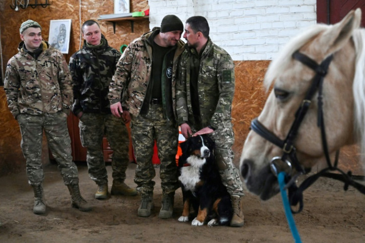 Ukrainian servicemen queue to ride a horse during their hippotherapy session