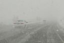 Vehicles drive during a snowstorm in Clearfield, Utah