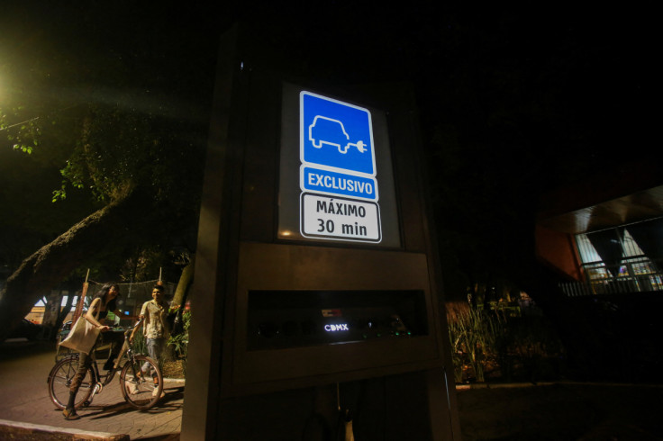People walk by an electric vehicle charging station in Mexico City
