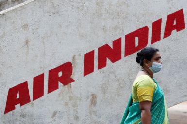 A woman walks past Air India airlines branding at a park in Mumbai