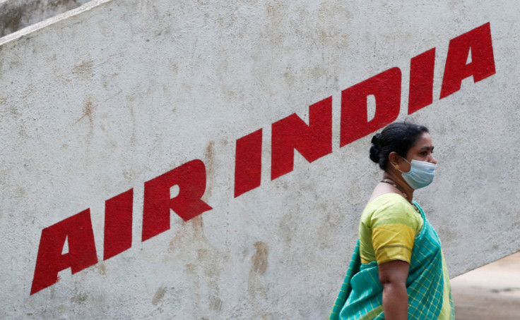A woman walks past Air India airlines branding at a park in Mumbai