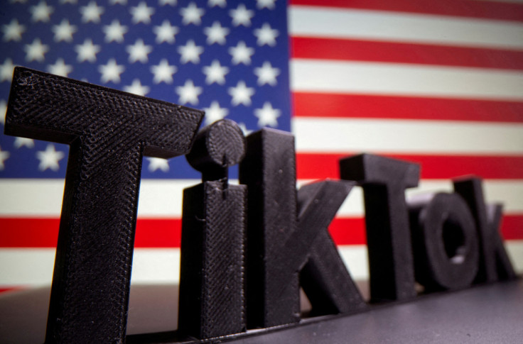 A 3D printed Tik Tok logo is seen in front of U.S. flag in this illustration
