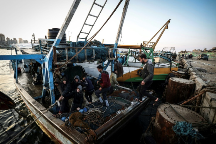 Palestinian fisherman Jihad al-Hissi and his sons aboard their boat at the seaport in Gaza City