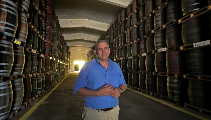 Cuban rum master Cesar Marti poses among hundreds of barrels in the Central Rum Distillery's cellar