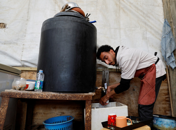 Mussa Toman, a Palestinian man, washes cups in his coffee shop in Gaza Strip
