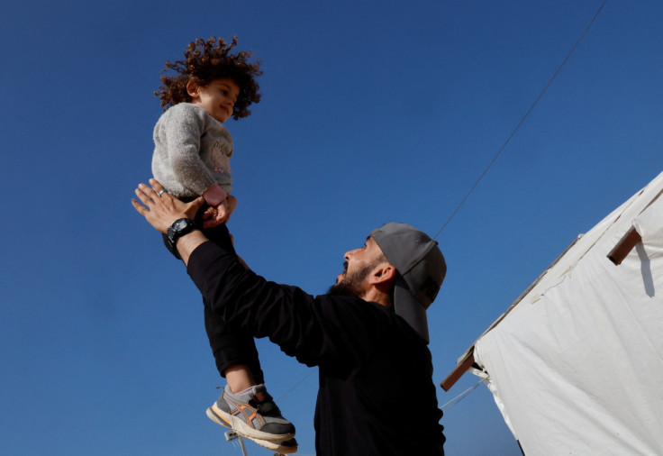 Moamen Toman, a Palestinian man, plays with his brother at his coffee shop in Gaza Strip