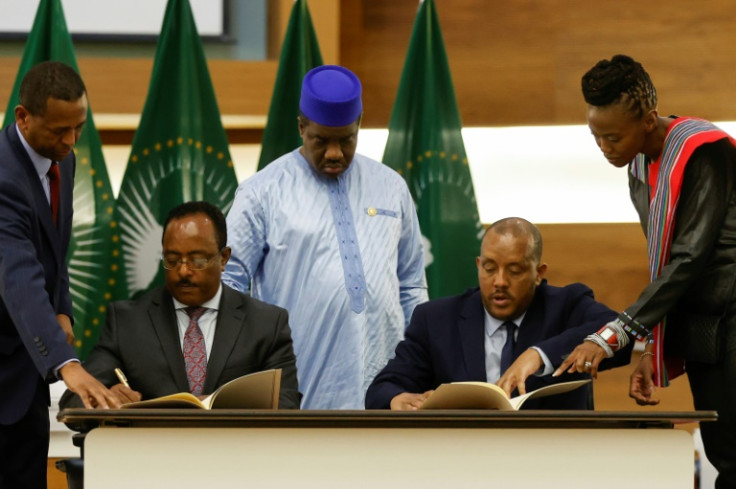 Ethiopian government representative Redwan Hussein, left, and Getachew Reda, representing the TPLF, sign the November 2 peace agreement in Pretoria