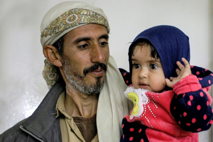 A man carries a child at al-Janatain Charity Medical Centre  in Yemen's Huthi-rebel-held capital Sanaa