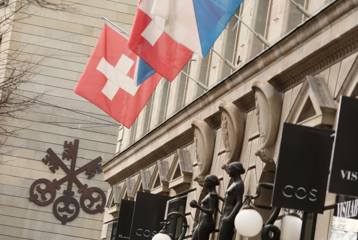 A logo of Swiss bank UBS is seen next to a Swiss flag in Zurich