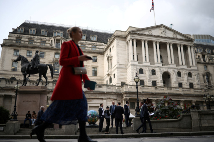 People stand outside the Bank of England in the City of London financial in London