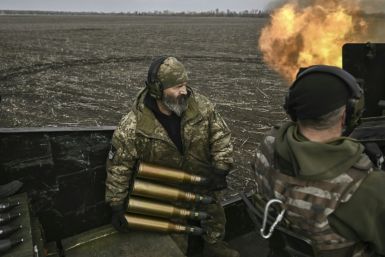 Ukrainian serviceman Chas reloads an anti-aircraft gun as his comrades fire at Russian positions near Bakhmut
