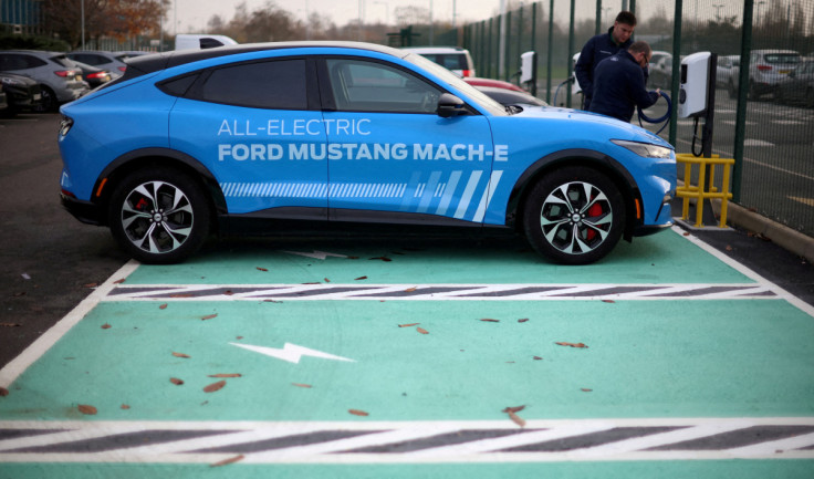 Workers plug in an electric Ford Mustang Mach-e electric vehicle during a press event at the Ford Halewood transmissions plant in Liverpool