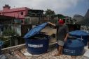 Jurandi Perera, a restaurant owner, checks his water container at his home in the Rocinha favela in Rio de Janeiro
